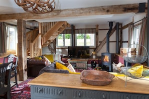 Open-plan sitting and dining area with exposed beams