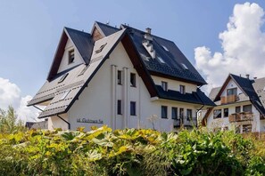 The property’s exterior showcasing a modern chalet-style design, framed by a clear blue sky.