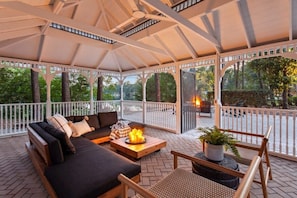Veranda with seating area and views of the fire pit