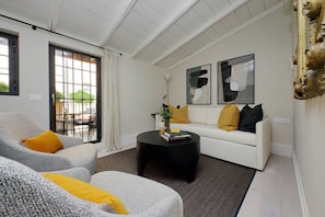 Charming living room with original beamed ceiling opens to the terrace.