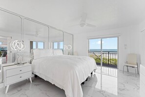 Elegant master bedroom with a king-size bed, mirrored accents, and a private balcony.