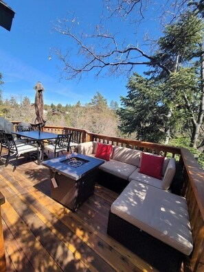 Stunning mountain views from this spacious wrap-around balcony, complete with comfortable lounge seating, a cozy gas fireplace, and a large outdoor dining area that is perfect for enjoying meals with friends and family.