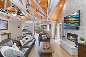 A perfect combination of rustic charm and modern comfort in this stunning open-concept living space, featuring bright natural wood accents and a stunning white slate fireplace.