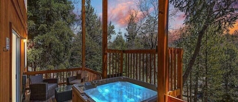Relaxation at its finest, soaking in the warm waters of the hot tub while admiring the breathtaking sunset over the Big Bear alpine trees.