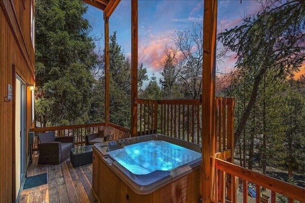 Relaxation at its finest, soaking in the warm waters of the hot tub while admiring the breathtaking sunset over the Big Bear alpine trees.