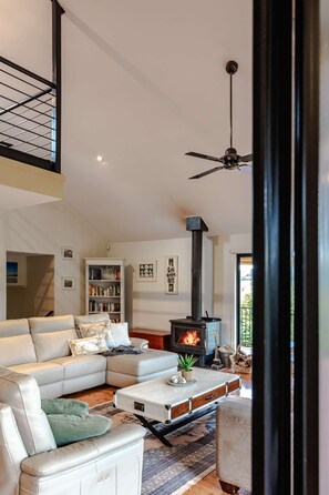 Open plan living area with high ceilings, fireplace and smart tv