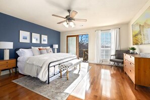 The King Suite on the main floor has a Smart TV, desk space, access to the back patio, and an attached full bathroom.