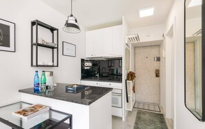 A functional kitchen with sleek black countertops, white cabinetry, and modern appliances for convenience.

