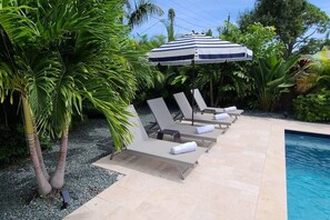Lounge poolside with 4 chairs & an umbrella