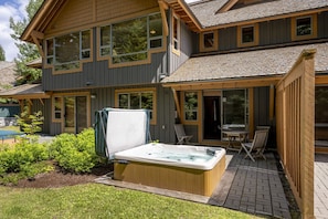 A view of the private hot tub in the summer. Plenty of backyard space with green grass for everyone to enjoy - especially kids!