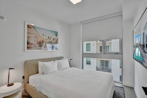 Bedroom with queen bed, and smart tv.