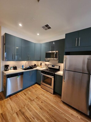 Step into this stunning kitchen featuring sleek stainless steel appliances and warm wood floors, creating a perfect blend of modernity and coziness.