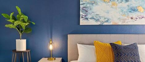The primary suite boasts a king sized bed, matching nightstands and reading lamps.