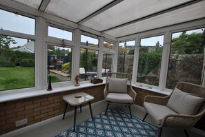 Overlooking the garden, the sunroom offers an extra space to relax