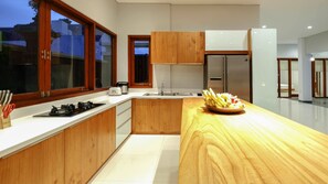 Spacious kitchen with modern appliances, cooking utensils, and dining ware