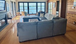 Upstairs common area features a large U-shaped couch, fireplace, smart TV & deck