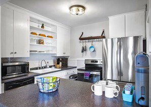 Open kitchen layout receives amazing morning natural light from a private back yard area. Fully stocked with cookware and serveware, oils & spices, Keurig coffee maker and more!