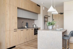 A functional kitchen with light wood cabinets, modern appliances, and a compact layout for convenience.