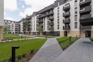 An exterior view of the residential complex, showcasing its landscaped gardens and contemporary design.