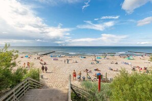 A beautiful beach view with a clear blue sky and sandy shore, offering a perfect getaway destination.
