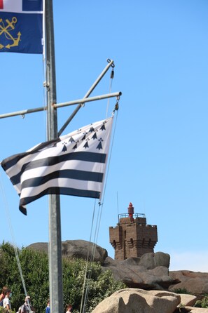 Au premier plan le drapeau breton. En arrière plan, le Phare de Ploumanac'h