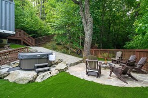 Fully fenced backyard with hot tub, fire pit area and tire swing