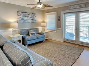 The living space with a sleeper sofa and balcony access