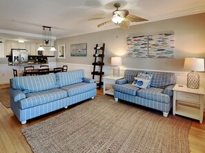 The living space with a sleeper sofa and balcony access