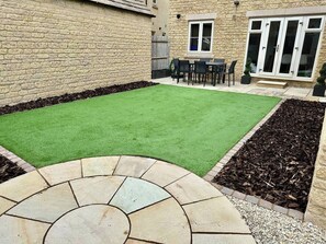Recently landscaped enclosed sunny garden with table and chairs to seat 6 and parasol.