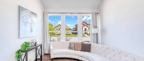 Chilling room, adorned with a curved sofa and boasting a breathtaking view.