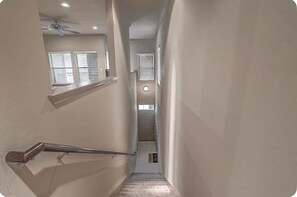 Stairwell with a door leading into the private garage attached to the apartment