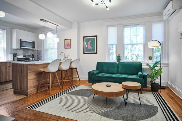 Spacious Living Room with Large Sofa, Reading Lamp, Bar Seating.