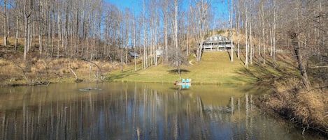 A picturesque mountain home overlooks a sprawling private pond.