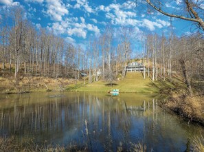 A picturesque mountain home overlooks a sprawling private pond.