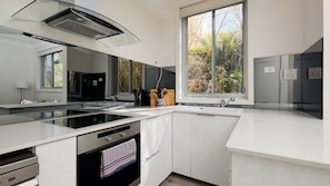 Experience culinary delight in our modern kitchen, equipped with high-end appliances and stylish finishes, perfect for creating memorable meals during your stay