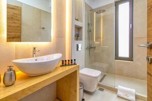 Modern and brightly lit bathroom with all the essential amenities and a sleek modern shower.
