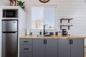 The kitchen is fully equipped with a refrigerator, freezer, microwave, cook-top and sink with hot/cold water. Enjoy coffee from the coffee maker, and find ample counter space, cookware, and storage for all your meal prep needs.