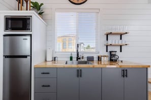 The kitchen is fully equipped with a refrigerator, freezer, microwave, cook-top and sink with hot/cold water. Enjoy coffee from the coffee maker, and find ample counter space, cookware, and storage for all your meal prep needs.