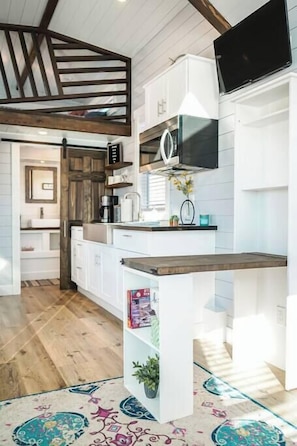 The kitchen is fully equipped with a refrigerator, freezer, microwave, cooktop and oven, and sink with hot/cold water. Enjoy coffee from the coffee maker, with cookware, dishes, utensils, and plenty of storage cabinets to keep everything organized.