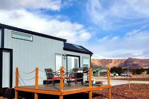 Relax on the spacious outdoor deck featuring a BBQ grill, a cozy fire pit, and a table with chairs for outdoor dining. Perfect for gatherings, this inviting space offers a great spot to cook, dine, and unwind while enjoying the fresh air.
