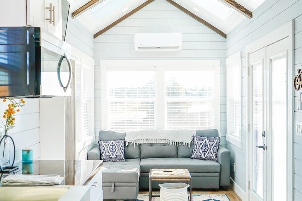Relax in the inviting living room featuring a comfortable couch, and a TV for entertainment. A sofa bed provides extra sleeping space, and with Wi-Fi access, this space is perfect for unwinding or enjoying your favorite shows and movies.