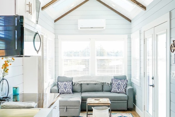 Relax in the inviting living room featuring a comfortable couch, and a TV for entertainment. A sofa bed provides extra sleeping space, and with Wi-Fi access, this space is perfect for unwinding or enjoying your favorite shows and movies.