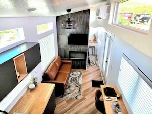 Relax in the inviting living room featuring a comfortable couch, a cozy fireplace, and a TV for entertainment. Stay connected with Wi-Fi access, making this space perfect for unwinding or enjoying your favorite shows and movies.