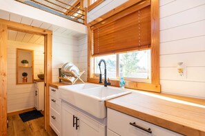 The kitchen is fully equipped with a refrigerator, freezer, microwave, stovetop and oven, and sink with hot/cold water. Enjoy coffee from the coffee maker, with cookware, dishes, utensils, and plenty of storage cabinets to keep everything organized.