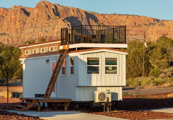 This charming tiny home features a cozy rooftop deck with stunning mountain views, a convenient parking space, and perfect conditions for stargazing. It’s a peaceful retreat surrounded by scenic natural beauty, ideal for relaxing or dining outdoors.