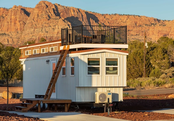 This charming tiny home features a cozy rooftop deck with stunning mountain views, a convenient parking space, and perfect conditions for stargazing. It’s a peaceful retreat surrounded by scenic natural beauty, ideal for relaxing or dining outdoors.