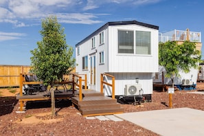 This charming tiny home features a cozy deck with stunning mountain views, a convenient parking space, and perfect conditions for stargazing. It’s a peaceful retreat surrounded by scenic natural beauty, ideal for relaxing or dining outdoors.