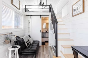 Relax in the inviting living room featuring a comfortable couch, a sofa bed for extra sleeping space, a cozy fireplace, and a TV. With Wi-Fi access, it’s the perfect spot to unwind or enjoy your favorite shows and movies in comfort.