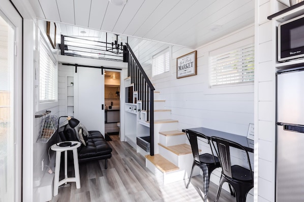 The dining area features a tabletop that maximizes space while providing a cozy spot to enjoy meals. Paired with comfy chairs, it’s the perfect blend of functionality and comfort in a stylish, space-saving design.