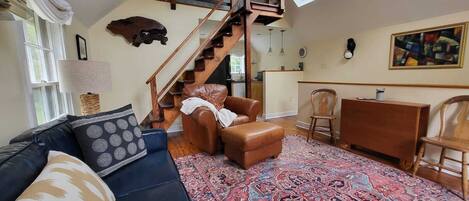 Vaulted ceiling great room with staircase to upper loft bedroom with queen bed.